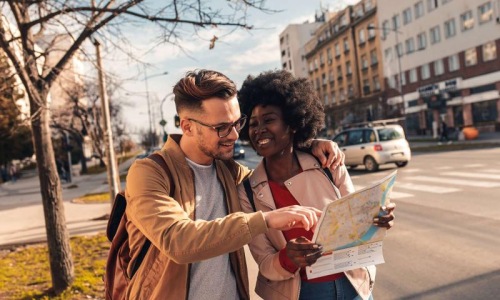 a man and woman looking at a map in the city