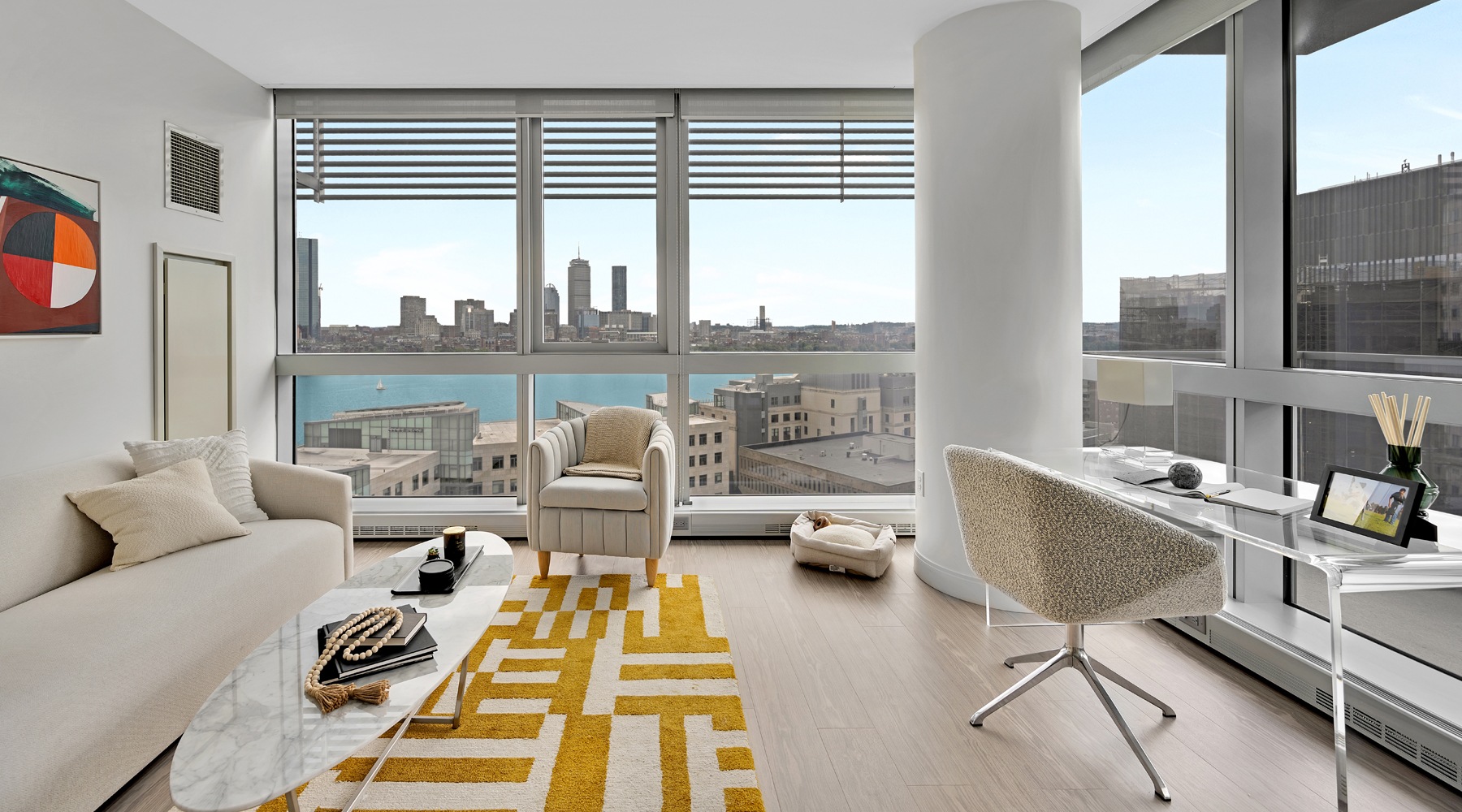A stylish living room of One65 Main apartment with modern decor, offering a stunning view of the bustling city outside through expansive windows
