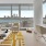 Modern living room with a large window view of a city skyline and water.